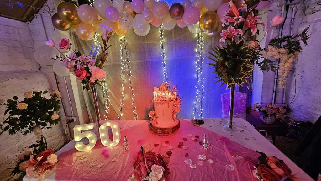 Decorated 50th birthday table with lights and balloons